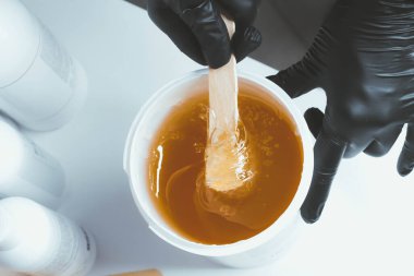 Shugaring ustası. Tüy dökümü için şeker ezmesi. Samimi hijyen. Yumuşak ten.