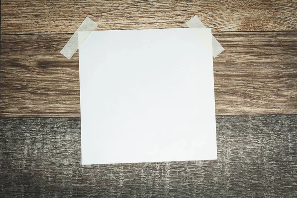 Una hoja blanca de papel se pega con cinta adhesiva. Plantilla de anuncio. —  Fotos de Stock