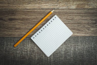 Not defteri ve kalem. Defterdeki notlar. Kayıtlar için şablon. Hatırlatma notu. Defterdeki şiirler. Karanlık bir arka planda boş bir defter ve kalem. Ahşap doku.