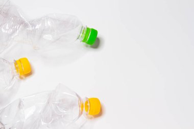 Plastik atıklar. Plastik şişeler. Atık ayıklama. Gezegeni çöpten temizlemek. Toprak temizliği. Plastik kaplardaki kapaklar sarı ve yeşildir. Kırışık plastik..