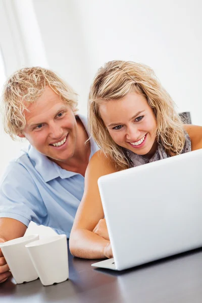 Happy young couple using laptop — Stock Photo, Image