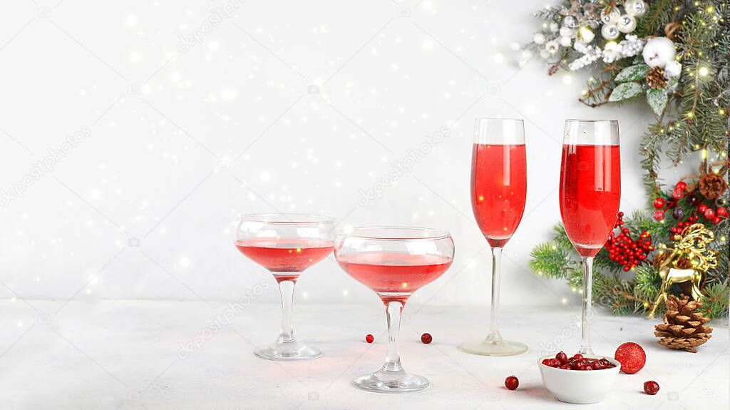 Christmas alcoholic or non-alcoholic cocktail with cranberry and cinnamon spice, red mimosa cocktail with champagne, warming winter drink in the cold season, christmas festive grog, winter composition, selective focus