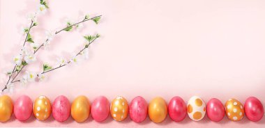 Mutlu Paskalyalar, bahar kartı, geçmiş. Süslü pembe Paskalya yumurtaları ve narin bir arka planda çiçek açan kiraz dalı. Asgari tatil konsepti, metin için yer, ekran için pankart, tasarım için şablon, seçici odaklanma