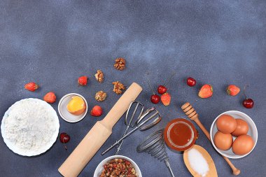 Mutfak geçmişi, yemek pişirme, çilekli turta tarifi. Yumurta, un, şeker, çilek ve bal, üst manzara, düz yatak. Fırın arka planı, modern fırın konsepti, seçici odak