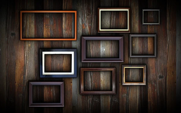 Frames on dark wooden wall — Stock Photo, Image