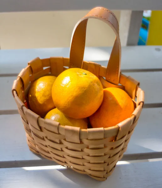 ส้มในตะกร้าบนเก้าอี้สีขาว . — ภาพถ่ายสต็อก