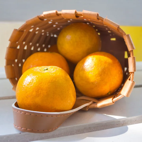ส้มในตะกร้าบนเก้าอี้สีขาว . — ภาพถ่ายสต็อก