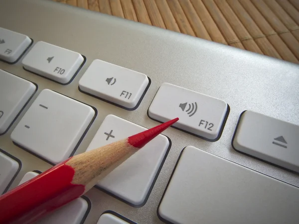 Pencil on keyboard buttons — Stock Photo, Image