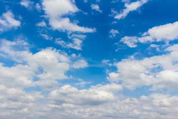 Blauwe lucht achtergrond met kleine wolken — Stockfoto