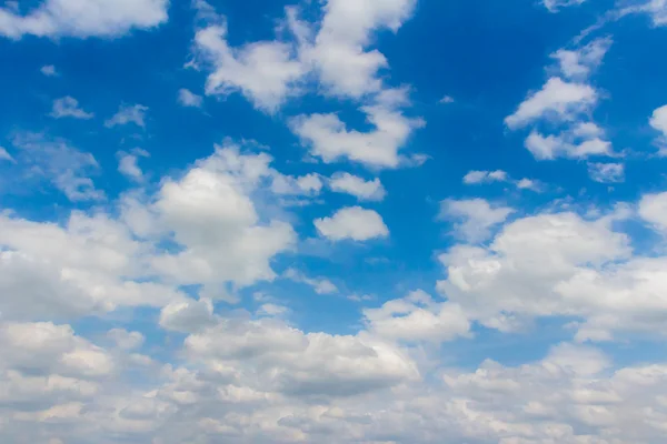 Blauwe lucht achtergrond met kleine wolken — Stockfoto