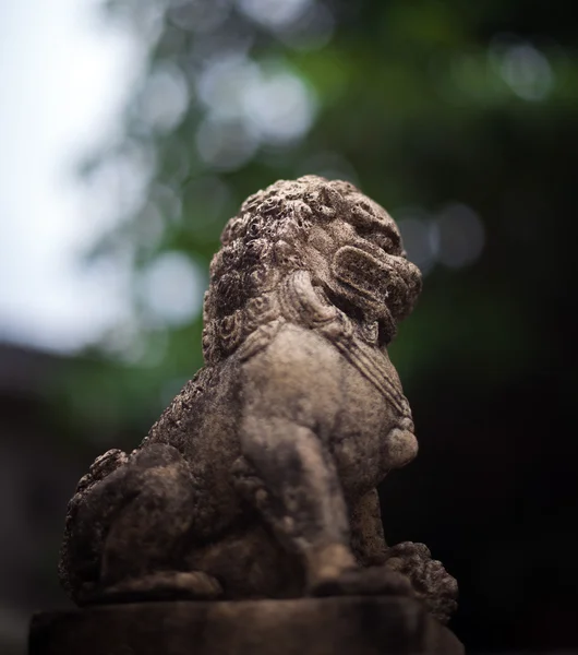 Une petite statue de lion sur le ciment — Photo