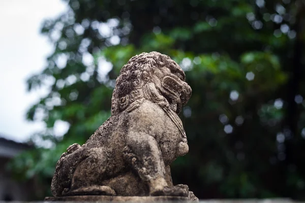 Une petite statue de lion sur le ciment — Photo