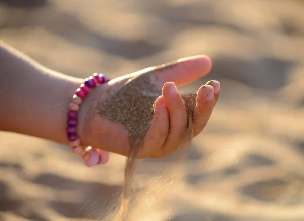 Sand pours out of the child hand — Stock Photo, Image