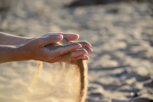 Le sable se déverse des mains — Photo