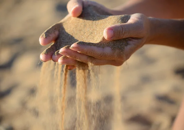 Sand pours out of the hands — Stock Photo, Image