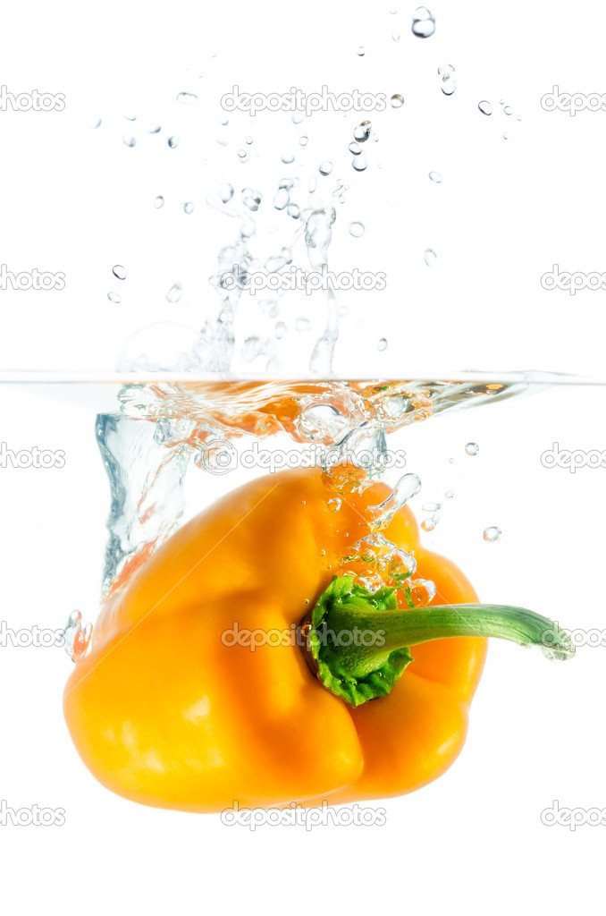 orange pepper falls in the water