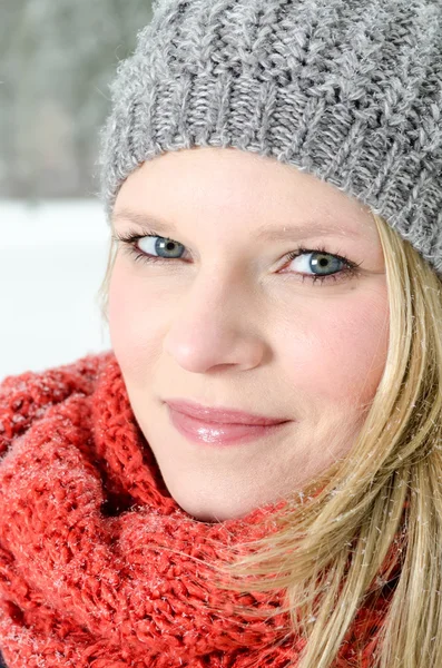 Jonge blonde vrouw met muts en sjaal winter hout portret — Stockfoto