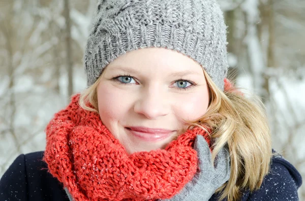 Ung blond kvinna med mössa och halsduk vintern trä porträtt — Stockfoto