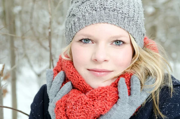 Jonge blonde vrouw met muts en sjaal winter hout portret — Stockfoto