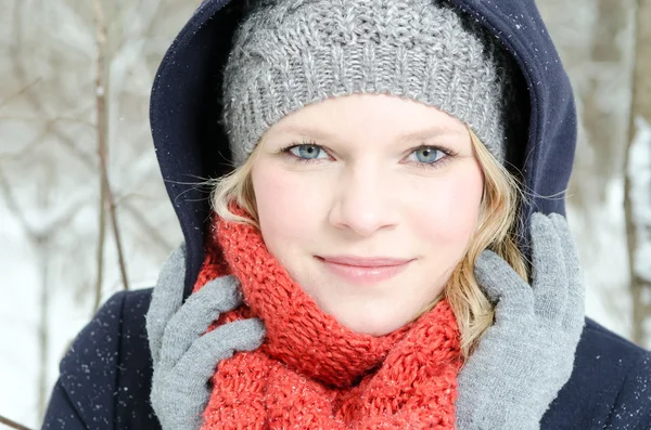 Ung blond kvinna med mössa och halsduk vintern trä porträtt — Stockfoto