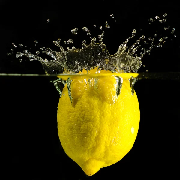 Un chorro de limones en el agua — Foto de Stock