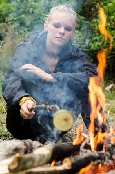 Blond young woman at the campfire — Stockfoto