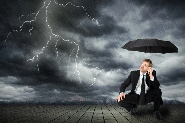 Takım elbiseli adam ve şemsiye fırtına barınağı — Stok fotoğraf