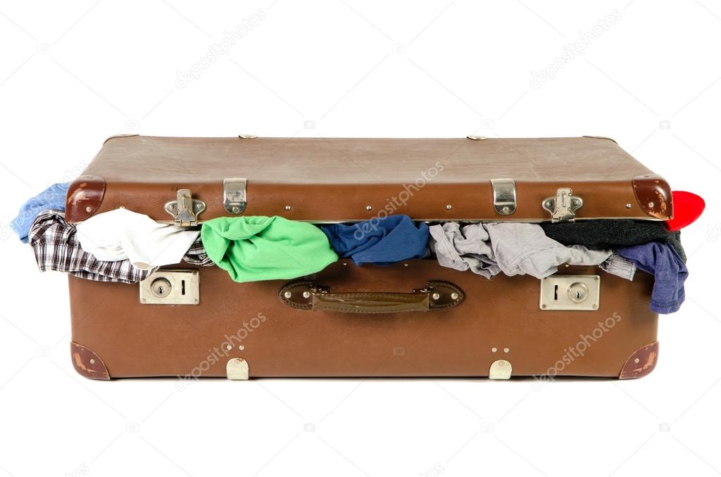 old suitcase full with clothes before white background