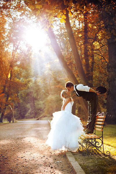 European bride and groom kissing in the park