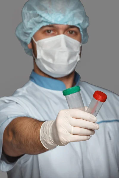 Médico joven con recipiente para análisis — Foto de Stock