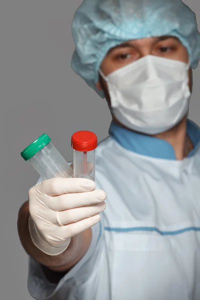 Young doctor with container for analysis — Stock Photo, Image