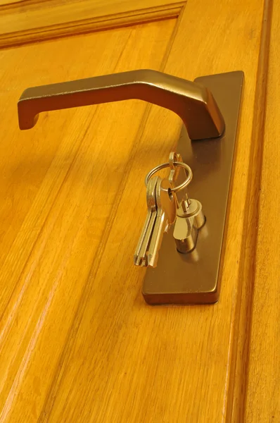 कुंजी का शीफ दरवाजे के पास एक कुंजी छेद में डाला जाता है — स्टॉक फ़ोटो, इमेज