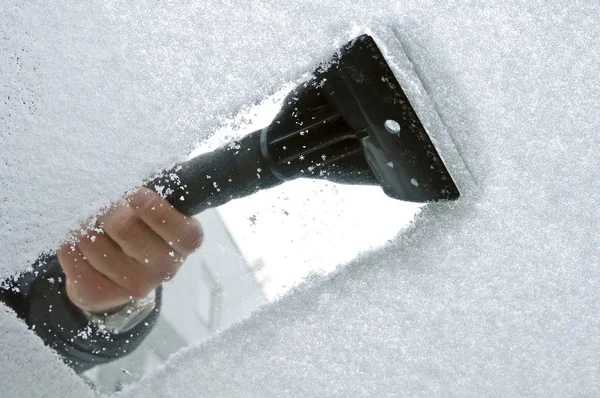 Raspando neve e gelo do pára-brisas do carro Fotos De Bancos De Imagens