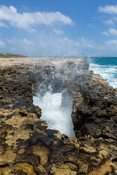 Vågorna kraschar genom klippiga öppning — Stockfoto