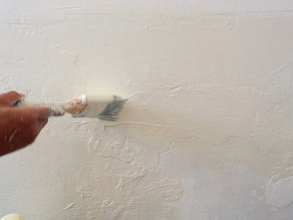 Blurry Brush Stroke. Blurry moving Female Hand painting the wall with paint brush. Home renovating with color.