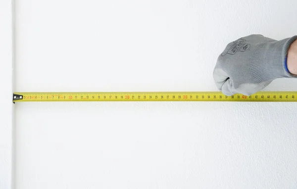 Вручите защитные перчатки с линейкой для измерения метра — стоковое фото