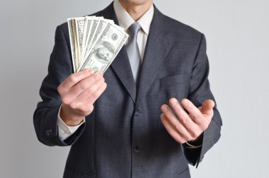 Takım elbiseli adam para gösterir