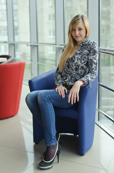 Jonge mooie vrouw zittend op een stoel — Stockfoto