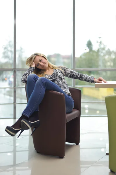 Jonge mooie vrouw zittend op een stoel — Stockfoto