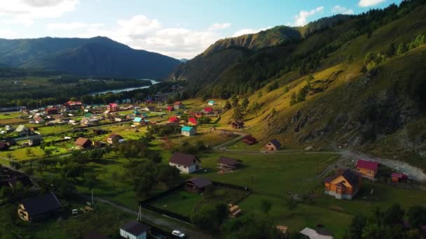 Birds-eye view of the Altai village of Chemal in a green mountain valley with a river. Rural summer landscape in the Altai Republic, Russia — Stock Video