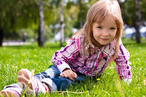 Young girl sitting on green grass — Stock Photo, Image