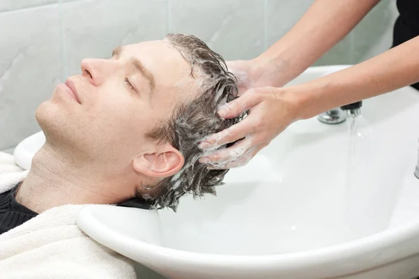 Rubia en un salón lavándose el pelo — Foto de Stock