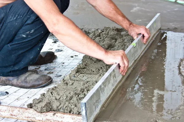 Plasterer concrete worker at floor work — Stock Photo, Image