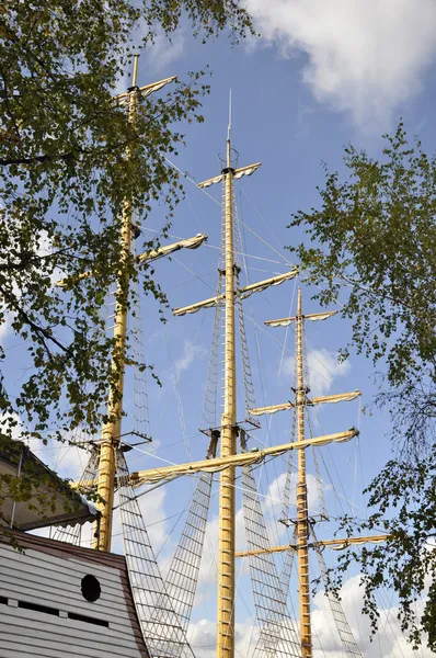 Mast ship on background of foliage and sky. — Stock Photo, Image