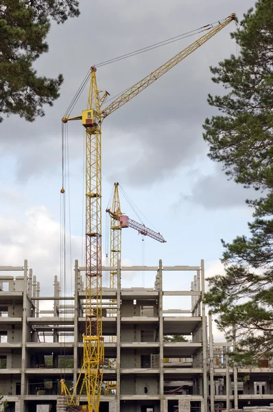 Construction crane on the background of trees. — Stock Photo, Image