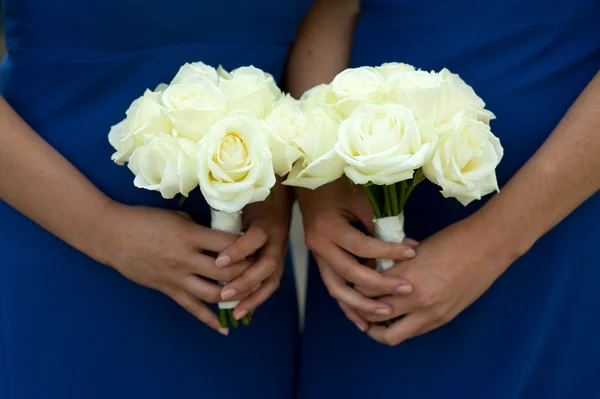 Twee bruidsmeisjes houden wit steeg bruiloft boeketten — Stockfoto