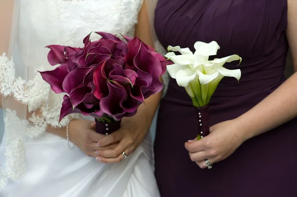 Bride and bridesmaid with wedding flowers — Stock Photo, Image