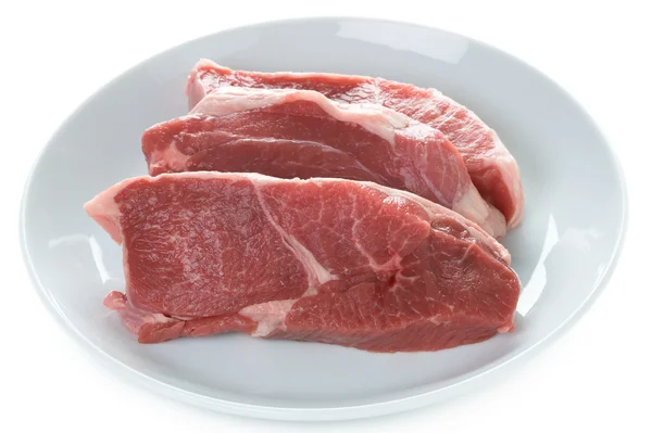 Raw lamb leg steaks on a white plate isolated — Stock Photo, Image