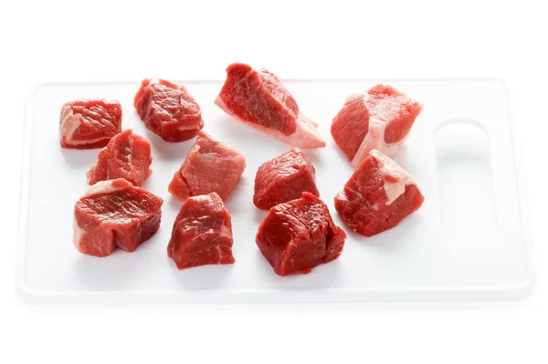 Raw cubes lamb on a chopping board — Stock Photo, Image