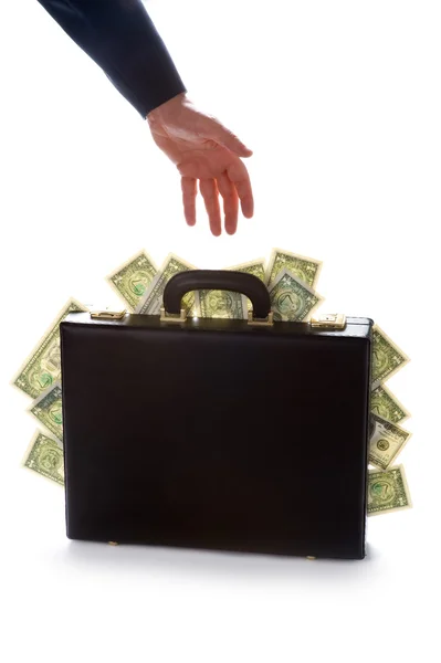 Businessman reaching for a briefcase full of money — Stock Photo, Image